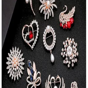 Exquisite collection of elegant pearl and crystal brooches shown on dark textured background