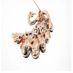 Detailed back view of rose gold metal swan brooch with delicate hollowed-out design