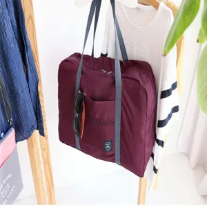 Μεγάλη ταξιδιωτική τσάντα duffel με ανθεκτικές γκρίζες λαβές και πρακτική μπροστινή τσέπη.