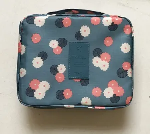 Primo piano della borsa cosmetica da viaggio floreale con comodo manico e toppa chic.