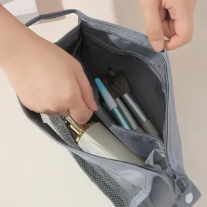 Grey travel cosmetic bag with mesh pockets, portable toiletry organizer with zipper.