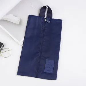 Detailed view of the dark blue travel shoe bag with vertical zipper and durable handle.