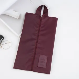 Wine red travel shoe bag detail, portable zipper organizer pouch for footwear protection and storage.