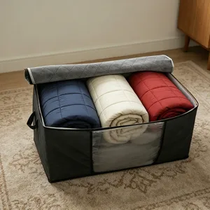 Close-up detail of large capacity grey quilted blanket storage bag filled with colorful quilts.