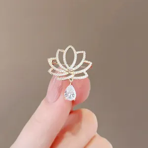 Elegant gold lotus brooch pin with a sparkling pear-shaped dangling crystal pendant