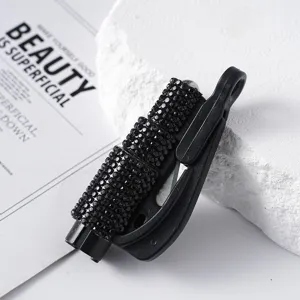 Macro view of a portable black rhinestone-studded emergency car window breaker tool