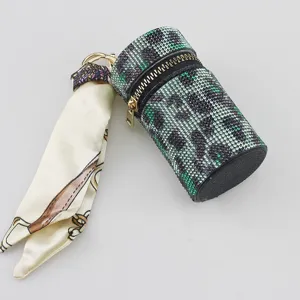 Close-up of leopard rhinestone lipstick case keychain with silk scarf detail