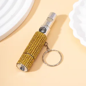 Nahaufnahme eines 3-in-1 Pfeife Kompass Taschenlampe Schlüsselanhängers mit goldenen Strass.