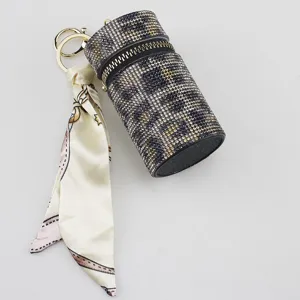 Detailed view of a luxury leopard rhinestone lipstick case keychain with silk scarf