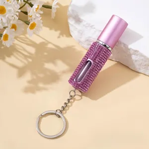 Gros plan d'un porte-clés atomiseur de parfum de 5 ml orné de brillants strass roses