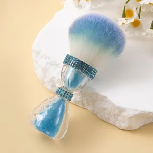 Detailed view of the blue rhinestone accents and gradient bristles on the makeup brush.