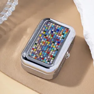 Close-up detail of a portable silver metal box decorated with vibrant multicolored rhinestones