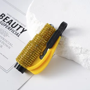 Detailed macro view of a yellow rhinestone-studded car window breaker and safety hammer tool.