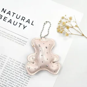 Close-up of a sparkling pink leather bear keychain with rhinestone accents
