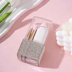 Primer plano de la caja de almacenamiento de brochas de maquillaje con pedrería y tapa.
