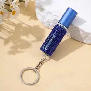 Gros plan d'un porte-clés vaporisateur de parfum 5ml orné de strass bleus