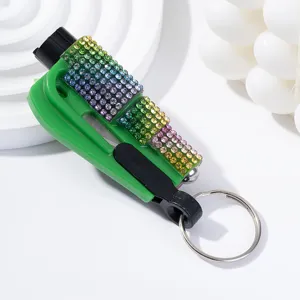 Macro view of a portable green car window breaker keychain with rainbow rhinestone detail
