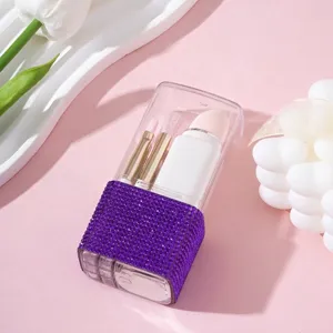 Detalle de un estuche portátil para brochas de maquillaje con pedrería púrpura brillante.