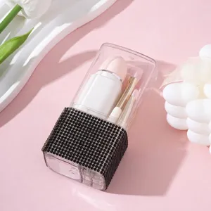 Detalle del porta brochas de maquillaje transparente con adornos de diamantes negros