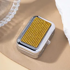 Detailed view of portable silver metal gift box with yellow rhinestone inlay design