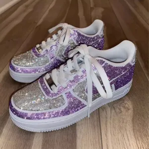 Nahaufnahme von funkelnden lila und silbernen Strasssteinen auf einem individuellen Sneaker