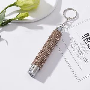 Close-up of champagne rhinestone-studded mini LED flashlight keychain with heart detail