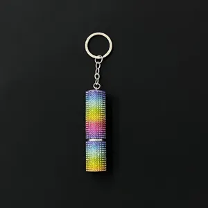 Macro view of a rainbow rhinestone-encrusted 5ml portable perfume spray bottle keychain.