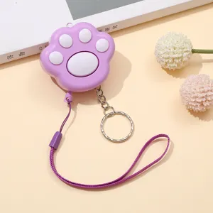 Primer plano de una alarma con forma de pata de gato lila con cordón y llavero a juego