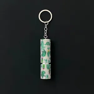Detailed close-up of a 5ml green camouflage rhinestone-encrusted perfume atomizer keychain.