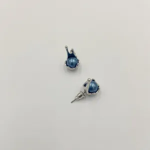 Vista detallada de pendientes de botón plateados con perlas azules