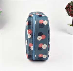 Vista laterale dettagliata di una borsa cosmetica impermeabile da viaggio con motivo floreale.