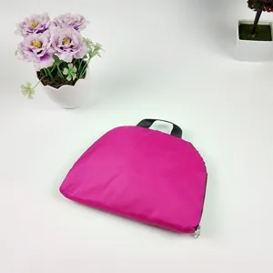 Detailed view of the folded pink lightweight oxford cloth travel backpack with zipper and black handle.