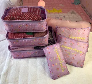 Vista detallada del juego de bolsas de viaje organizadoras moradas con cerezas, malla y cremallera.