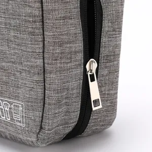Grey portable travel toiletry bag makeup organizer with durable zipper and fabric texture detail.