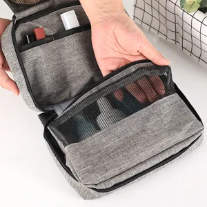 Portable travel toiletry bag with multiple compartments and mesh pockets in gray color