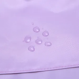 Detailed view of the purple waterproof travel bag fabric showing excellent water-repellent drops.