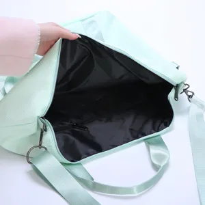 Detail view of the black interior lining and zippered pocket in a mint green travel bag