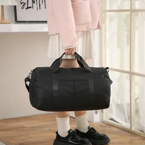 Detail shot of black travel duffel bag showing durable fabric handles and spacious capacity.