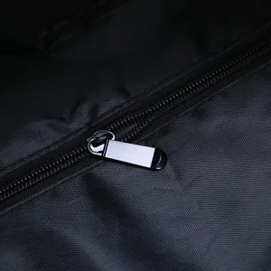 Macro close-up showing the durable metal zipper and fabric of a black travel bag