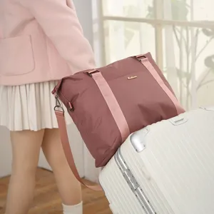 Waterproof travel duffel bag detail, showing handle strap and suitcase placement style.