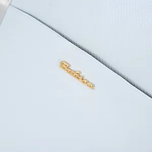 Macro view showing the light blue waterproof fabric and gold metallic Fashion logo of a bag