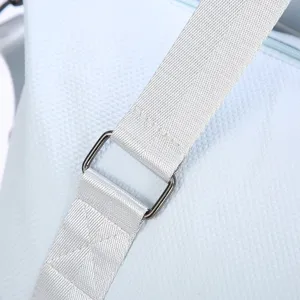 Close-up of waterproof fabric and sturdy shoulder strap on light blue travel bag