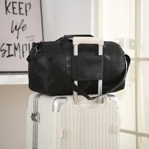 Large capacity black travel duffel bag with luggage sleeve and shoulder strap for gym.