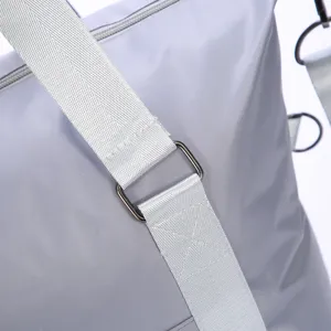 Durable grey travel duffel bag shoulder strap detail featuring strong hardware and sturdy stitching.