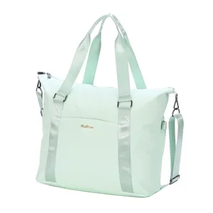 Detailed view of lightweight mint green waterproof travel bag with gold Fashion logo plate