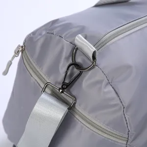 Grey travel duffel bag detail shot showing durable metal hooks, zippers, and sturdy straps.