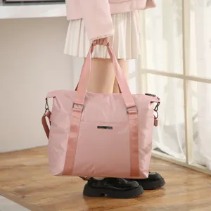 Large capacity pink travel bag detail, waterproof nylon luggage tote for business.