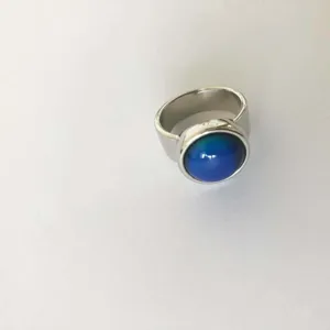 Primer plano de un anillo con piedra de humor redonda sensible a la temperatura y plata