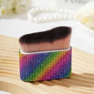 Vue détaillée d'un pinceau de maquillage de luxe avec un manche en strass arc-en-ciel coloré