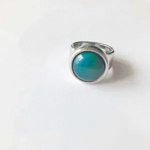 Vista detallada de un anillo de plata minimalista con una piedra que cambia de color